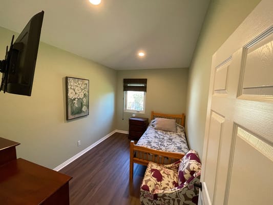 A bright private resident room with a bed and decor