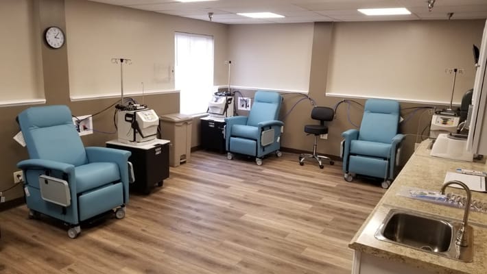 Interior view of a treatment room with blue chairs