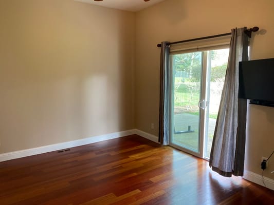 Spacious bedroom with hardwood floors and patio door