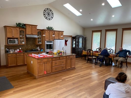 Spacious kitchen and dining area with residents interacting