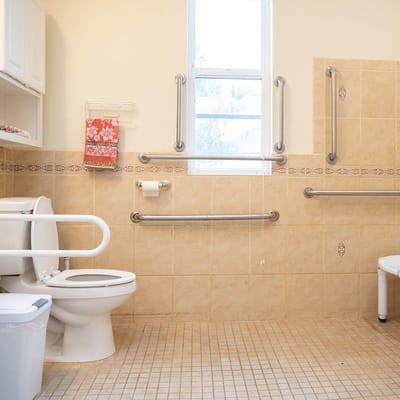 Spacious bathroom with safety grab bars and accessible toilet
