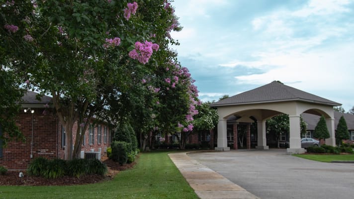 Entrance view of assisted living facility with flowering trees