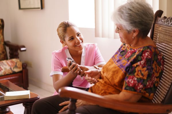 A caregiver interacting with a senior resident in a comfortable setting