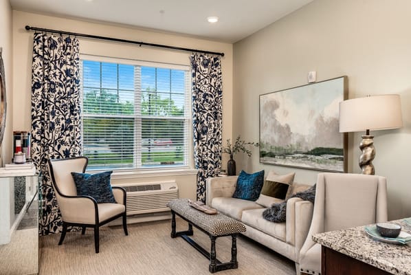 A comfortable living room with a sofa, decorative pillows, and large window.