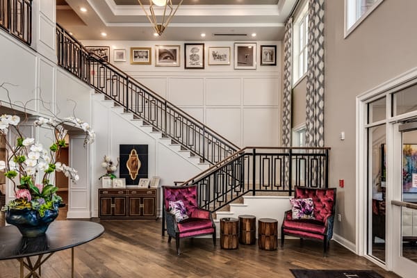 Elegant lobby featuring a staircase and stylish seating.