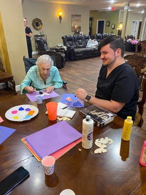 Resident and staff engaged in an arts and crafts activity