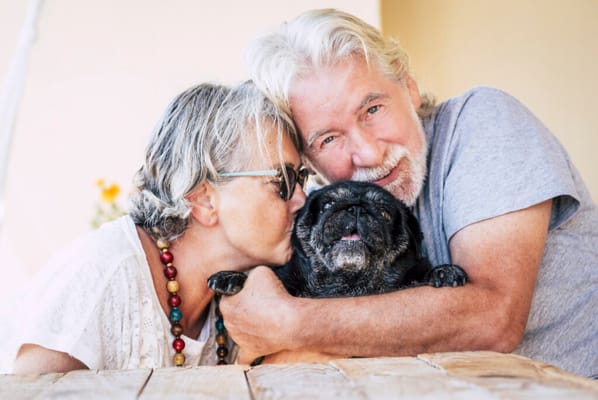 Senior couple happily posing with their dog