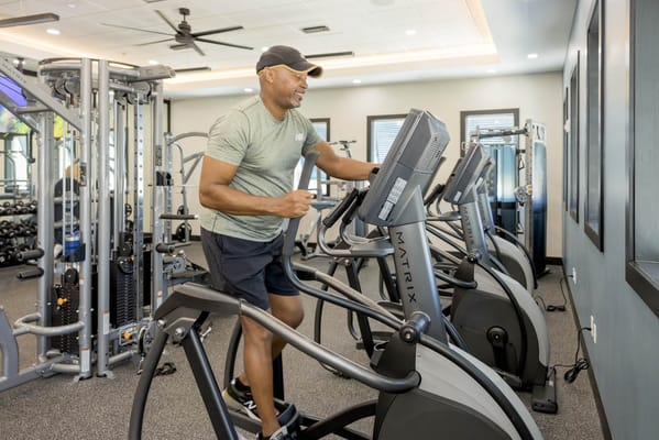 A resident using an elliptical machine in the fitness area