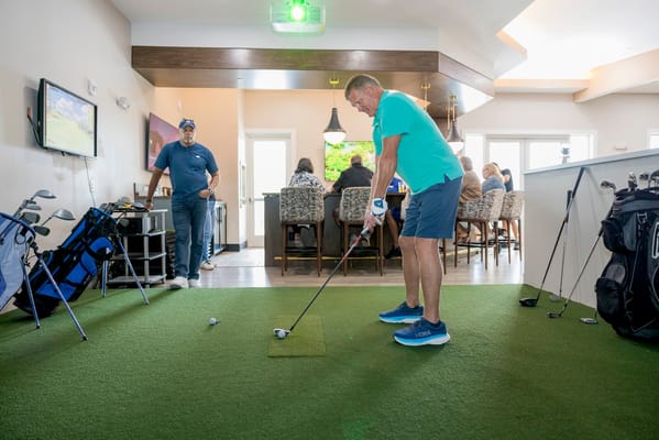 Residents engaging in indoor golfing activity
