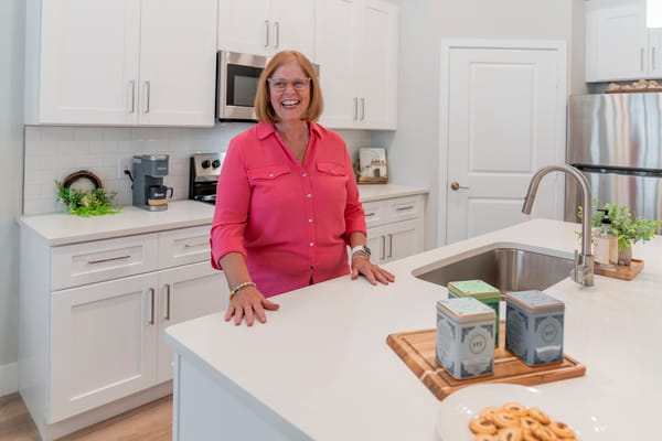 Resident smiling in a modern kitchen setting