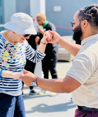 Residents engaging in a joyful outdoor dance activity