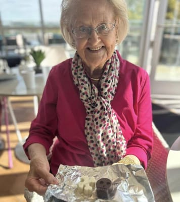 Resident holding chocolate treats with a smile
