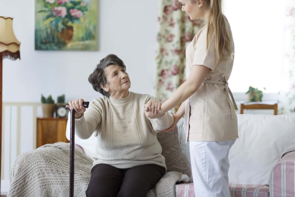 Caregiver assisting a senior resident in a cozy room