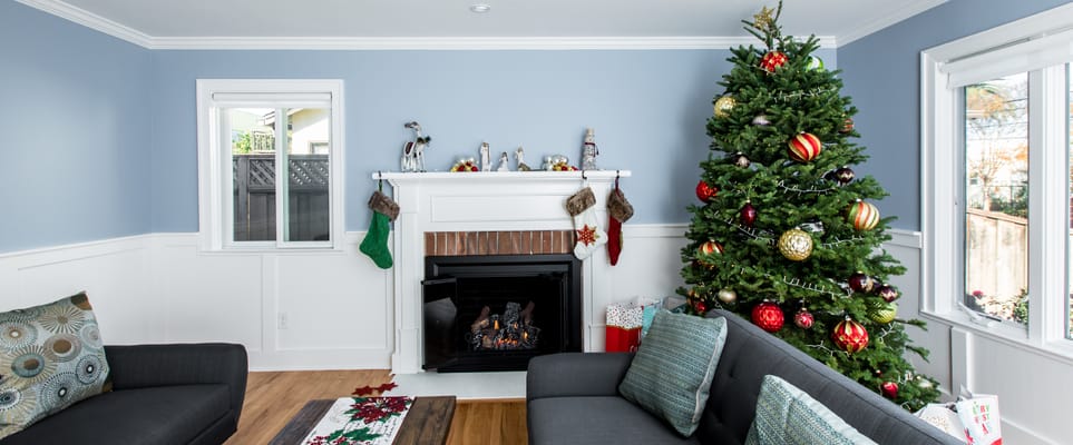 Cozy living room with a Christmas tree and fireplace