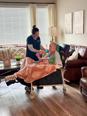 Caregiver assisting a resident in a cozy interior