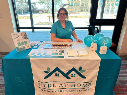 Staff member at a promotional table with materials