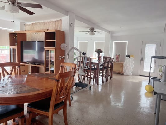 Bright common area with dining tables and TV