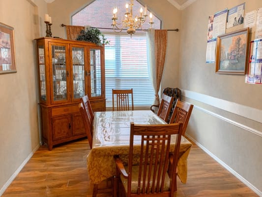 Interior dining area with wooden chairs and a chandelier