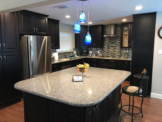 Spacious kitchen with dark cabinets and granite countertop