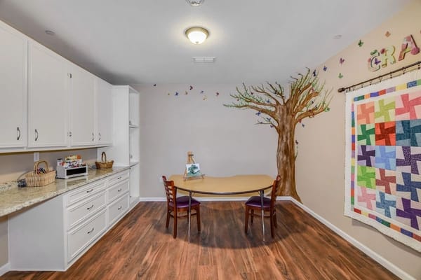 Bright activity room with a tree mural and table