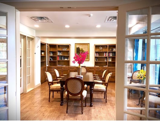 Welcoming library space with a wooden table and chairs, featuring shelves with books.