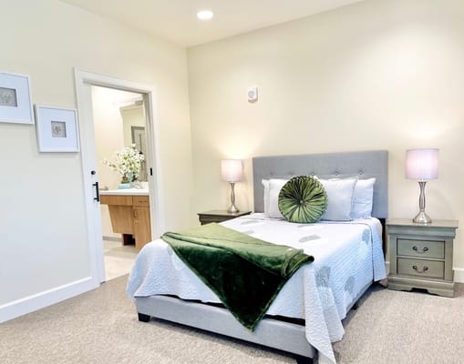 Brightly lit bedroom with a bed and soft decor.