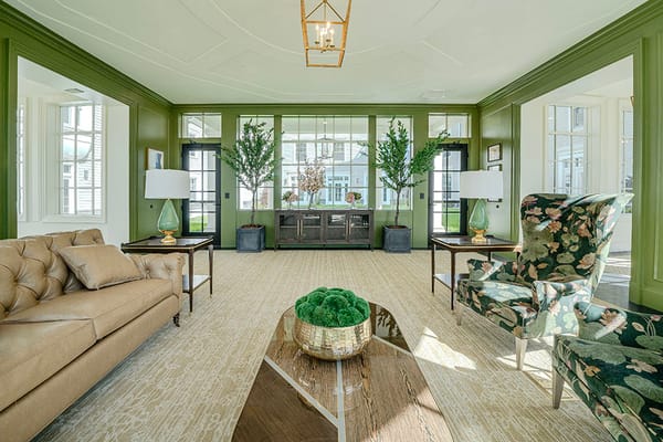 Cozy living room with green accents, plants, and elegant furniture.