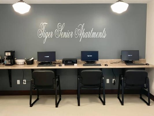 A computer work area with three desks and a coffee station.