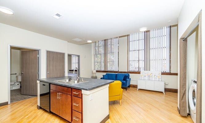 Interior view of a sunny resident room with a kitchenette