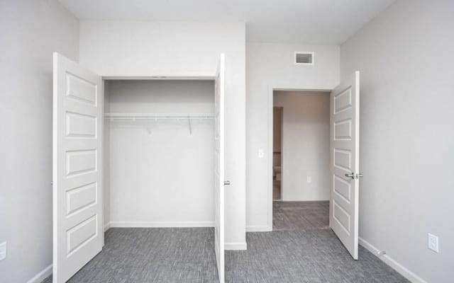 View of a bedroom closet with open doors