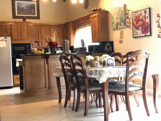 Cozy dining area with wooden furniture and floral tablecloth.