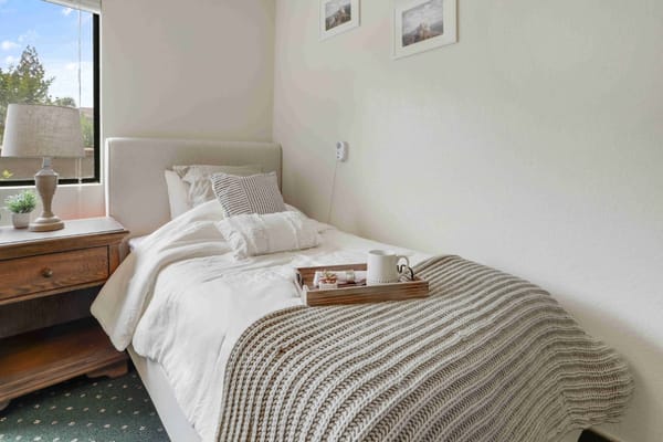 Cozy resident room with a bed and side table