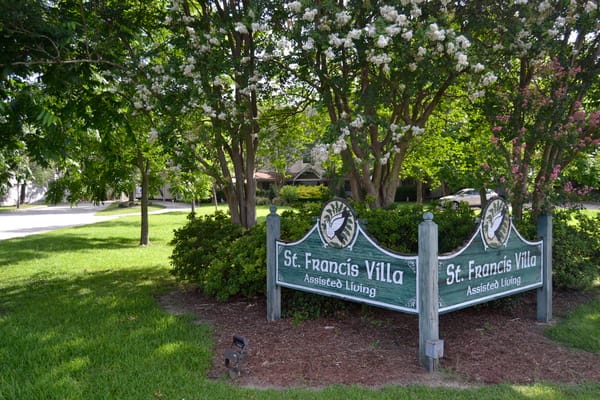 Sign for St. Francis Villa Assisted Living surrounded by greenery