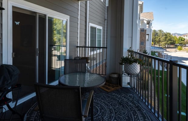 Cozy balcony with a table and chairs overlooking the courtyard