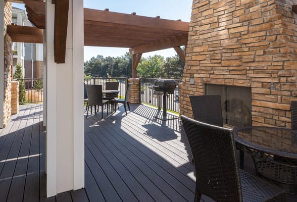 Outdoor patio with stone fireplace and seating area