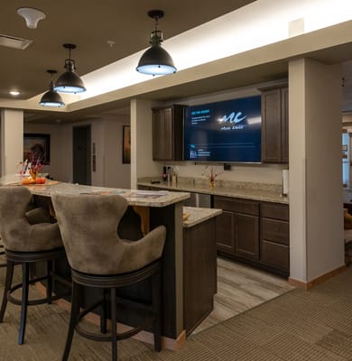 Modern bar area with high stools and a large TV display