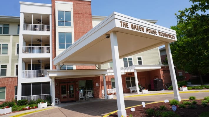Entrance of Stadium Place Nursing and Rehab Center with covered awning and seating area.