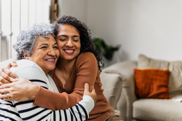 Two women hugging in a cozy living room