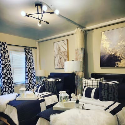 Well-decorated bedroom with two beds, art, and lamps.