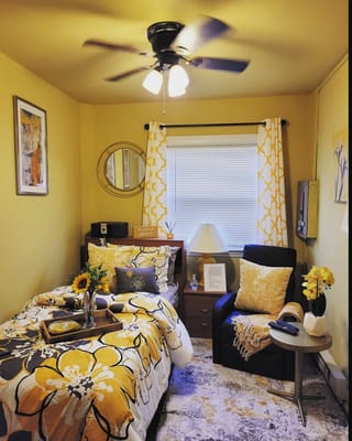 A beautifully decorated bedroom with floral bedding and a seating area