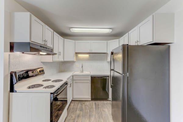 Kitchen with white cabinets and appliances at Paramount Garden Apartments