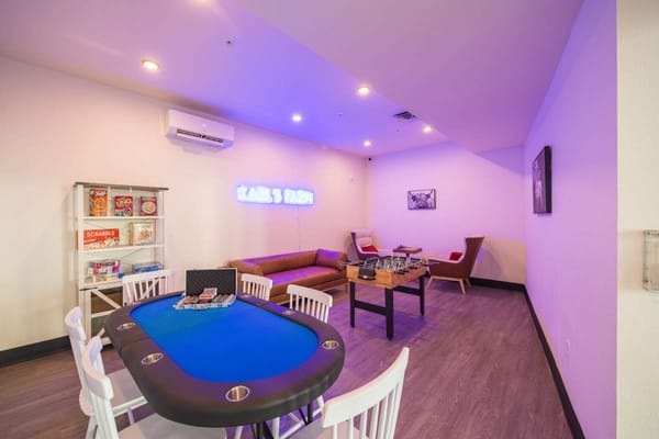 A game room with a poker table, board games, and a cozy seating area.