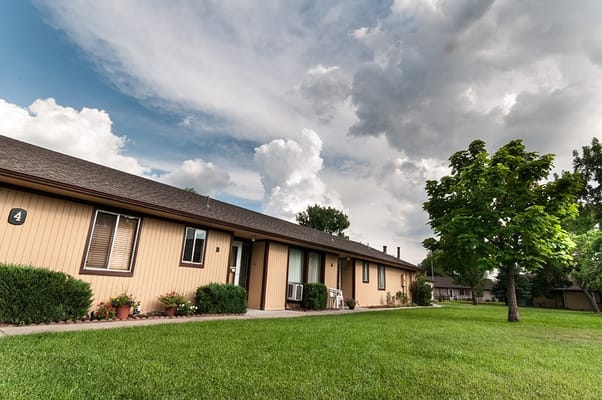 Exterior view of a senior living building with green lawn
