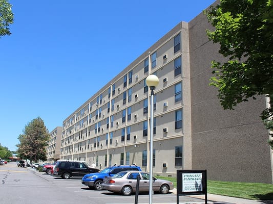 Exterior view of Marcella Manor Apartments with parked cars