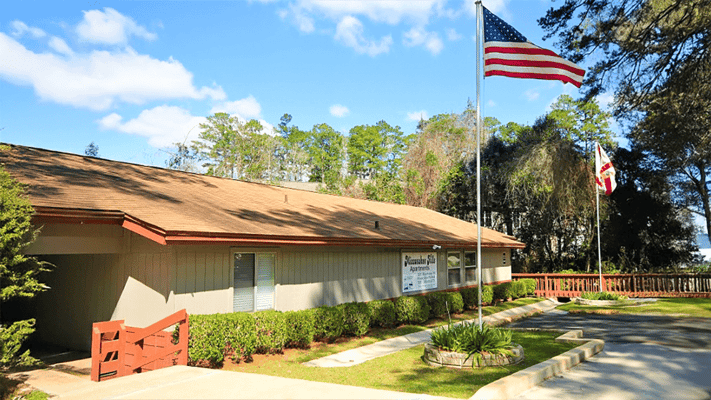 Exterior view of Miccosukee Hills Apartments with flags
