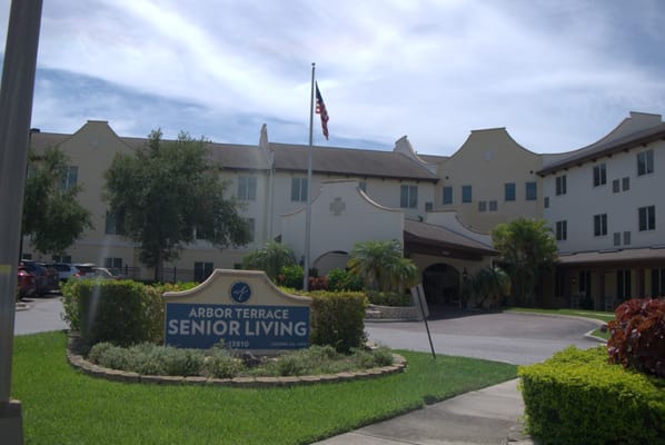 Entrance of Arbor Terrace Citrus Park with sign and landscaped entrance.