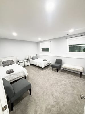 A shared resident room with two beds and seating