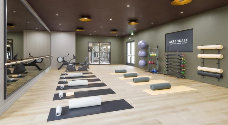 Yoga studio with mats, exercise equipment, and mirrored wall at Aspendale Centennial