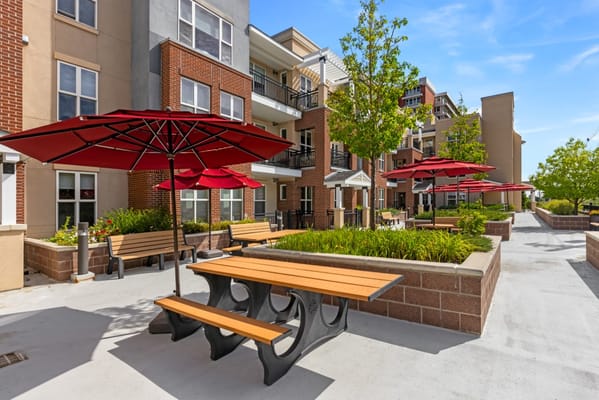 Outdoor seating with red umbrellas at Flatirons Terrace.