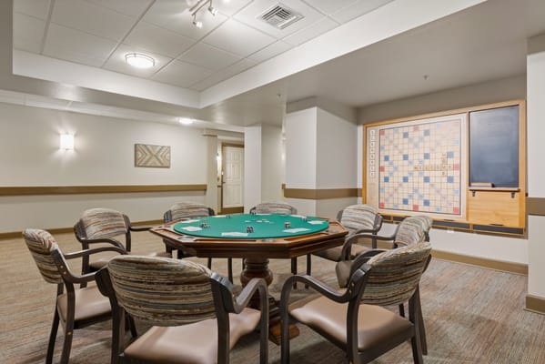 Game room with a green poker table and scrabble board